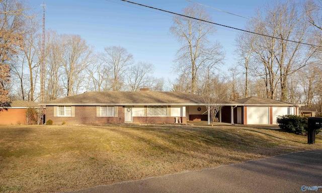 single story home featuring a garage, a front yard, brick siding, and a chimney