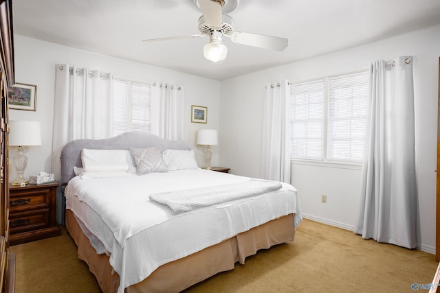 bedroom featuring baseboards, a ceiling fan, and light colored carpet