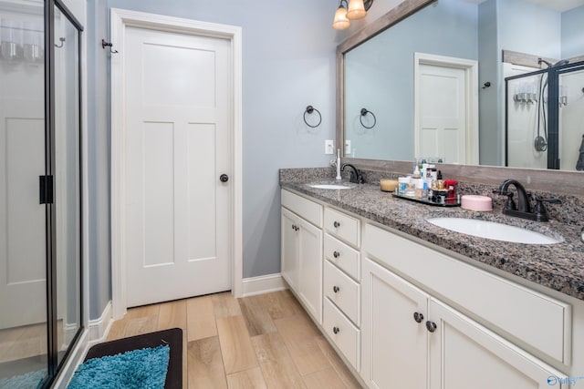 3032 SE Greenway Cir, Owens Cross Roads, AL 35763 - full bathroom with a stall shower, wood finished floors, baseboards, and double vanity