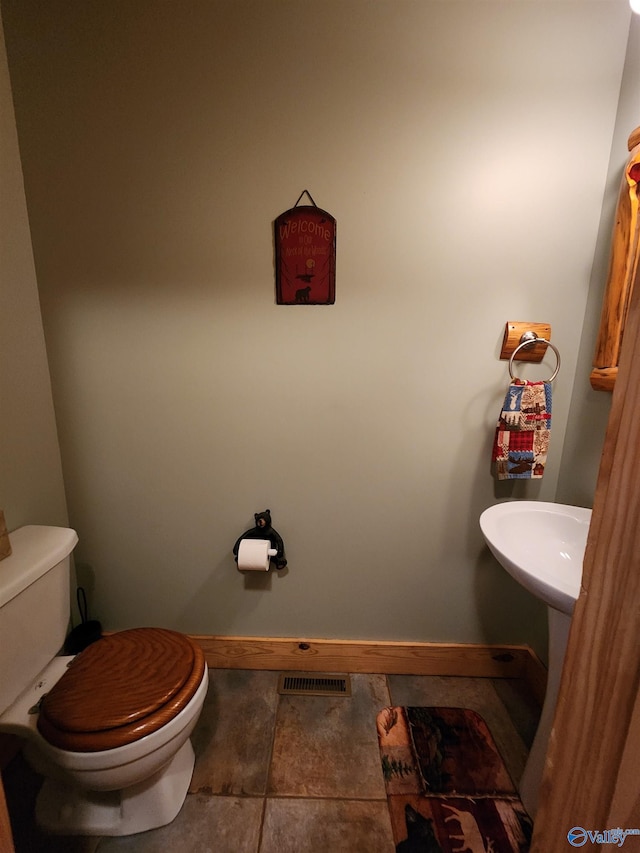 bathroom featuring toilet and tile patterned flooring