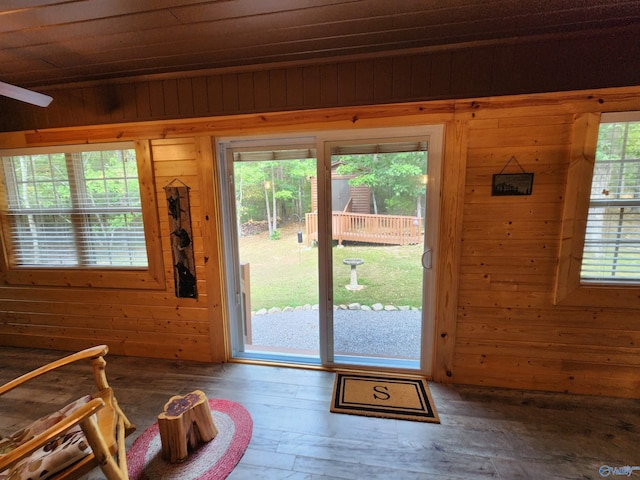 doorway to outside featuring wood walls, wood-type flooring, and wooden ceiling