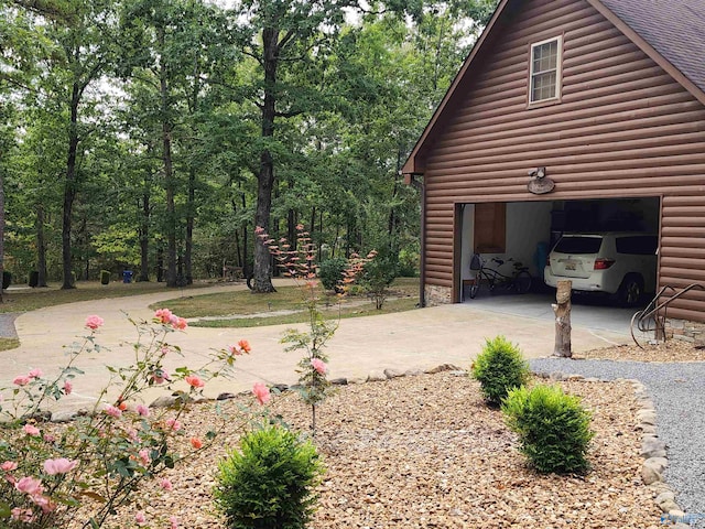 view of side of home featuring a garage and an outbuilding