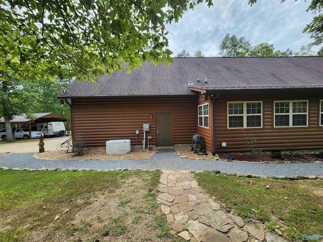 back of house featuring a lawn and a carport