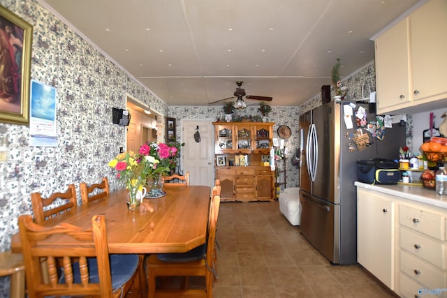 dining space with ceiling fan and wallpapered walls