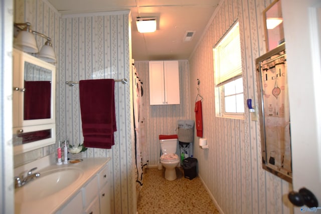 bathroom featuring toilet, visible vents, and wallpapered walls