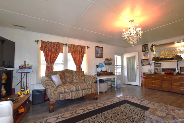 living area with a chandelier, wood finished floors, and a healthy amount of sunlight