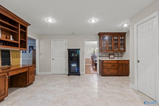 kitchen with a textured ceiling, tasteful backsplash, light hardwood / wood-style floors, crown molding, and sink