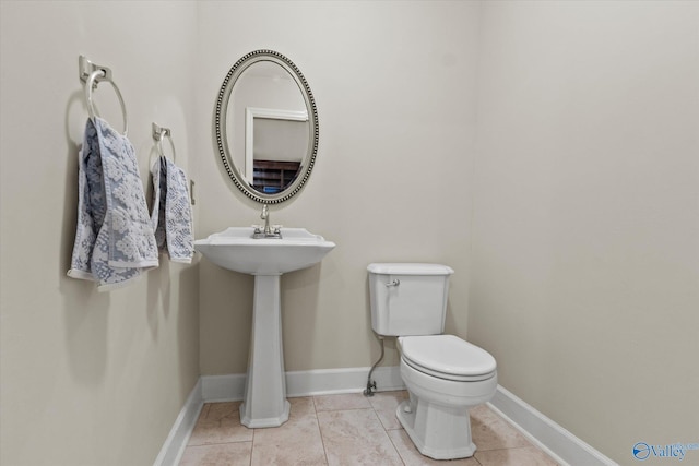 bathroom featuring baseboards, toilet, and tile patterned floors