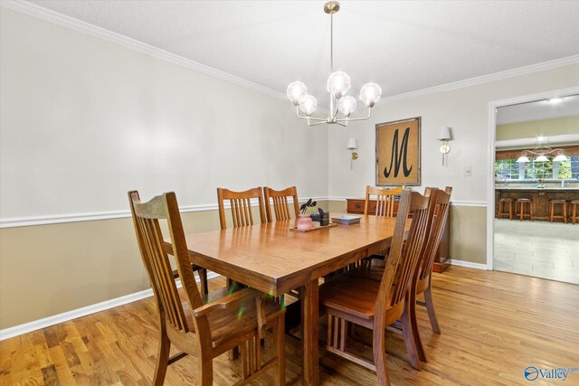 dining space featuring hardwood / wood-style flooring, an inviting chandelier, crown molding, and a textured ceiling