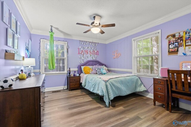 bedroom with crown molding, ceiling fan, and wood-type flooring