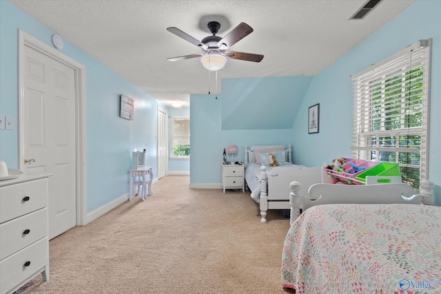 carpeted bedroom with lofted ceiling, visible vents, a textured ceiling, and baseboards