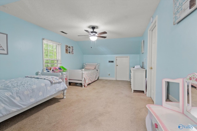 bedroom featuring ceiling fan, a textured ceiling, visible vents, vaulted ceiling, and carpet