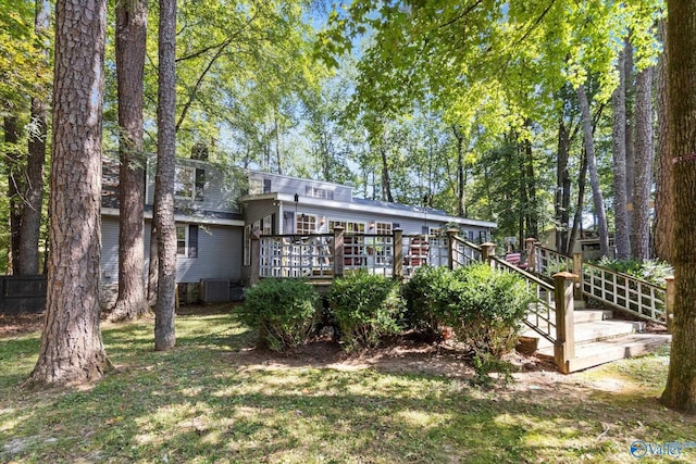 rear view of property featuring a deck, fence, and central air condition unit