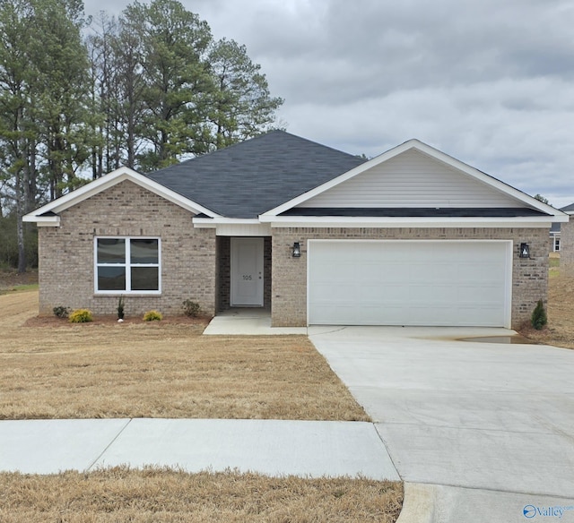 ranch-style home featuring a garage, a front yard, brick siding, and driveway