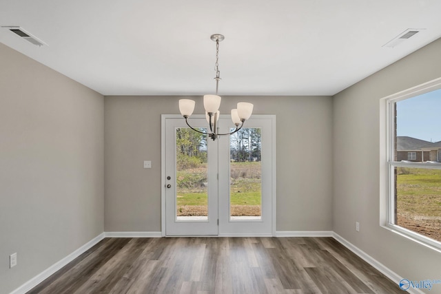 unfurnished dining area with a wealth of natural light, visible vents, and wood finished floors