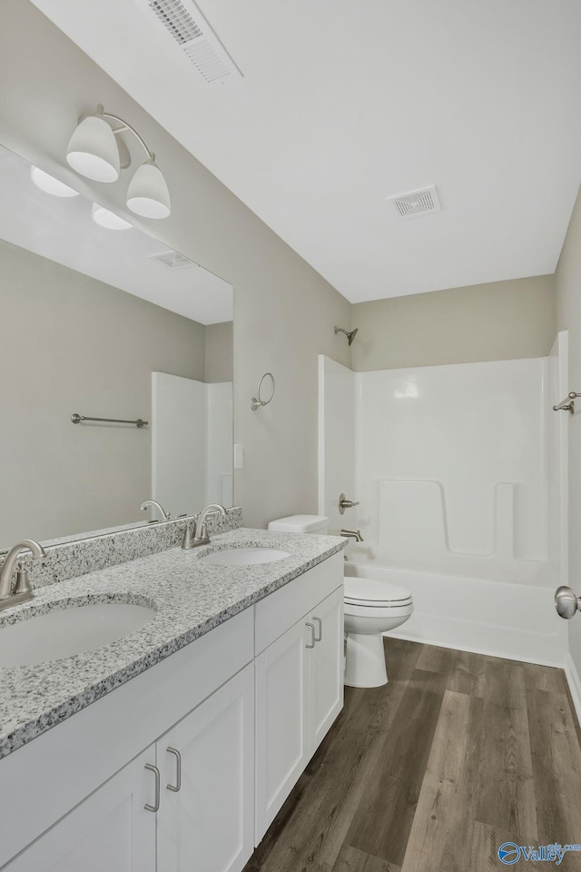 bathroom featuring visible vents, wood finished floors, and a sink