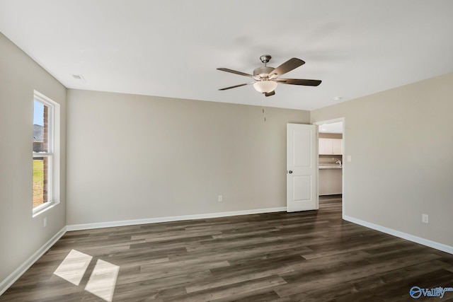 unfurnished bedroom featuring visible vents, baseboards, dark wood-type flooring, and ceiling fan