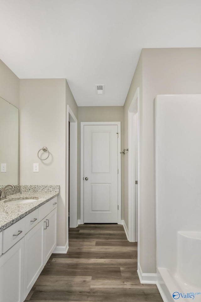 full bath featuring visible vents, baseboards, wood finished floors, and vanity