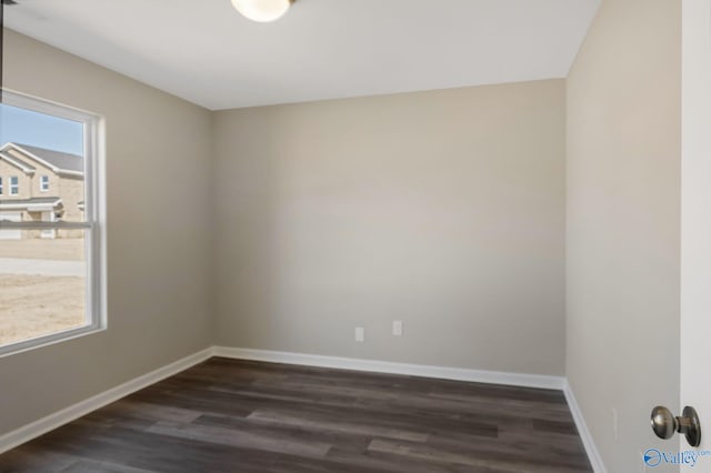 unfurnished room with dark wood-style floors and baseboards