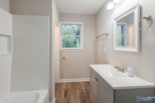 bathroom with hardwood / wood-style floors, vanity, and tub / shower combination