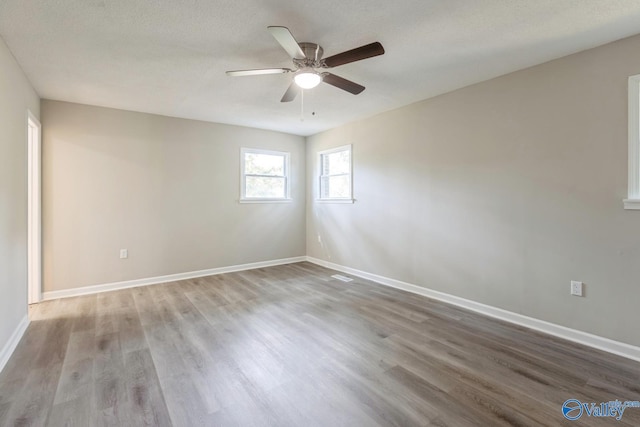 unfurnished room featuring hardwood / wood-style floors, ceiling fan, and a textured ceiling