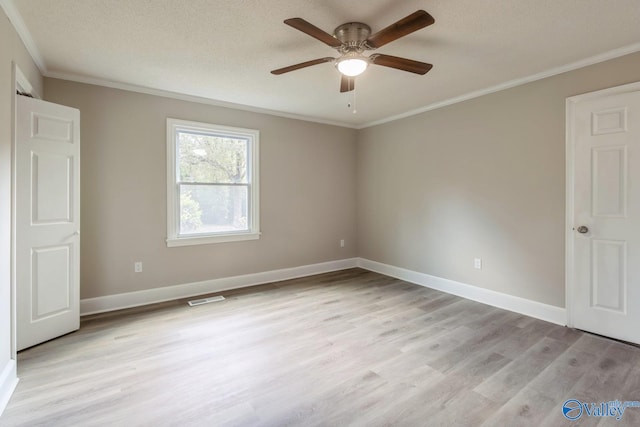 empty room featuring ceiling fan, light hardwood / wood-style floors, crown molding, and a textured ceiling