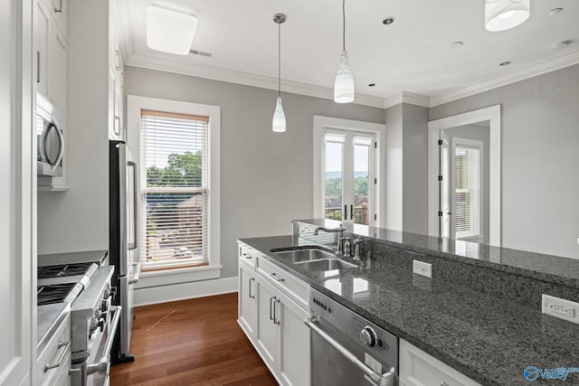 301 NE Holmes Ave Unit 404, Huntsville, AL 35801 - kitchen with appliances with stainless steel finishes, white cabinets, dark wood-style flooring, healthy amount of natural light, and crown molding