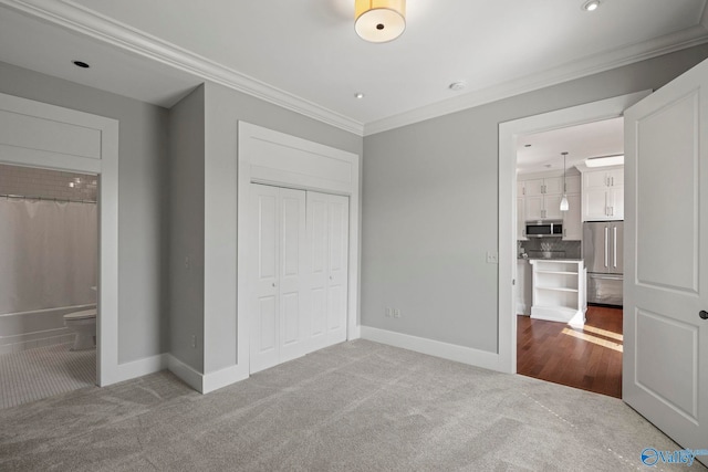 301 NE Holmes Ave Unit 404, Huntsville, AL 35801 - unfurnished bedroom with high end refrigerator, crown molding, carpet floors, a closet, and ensuite bath