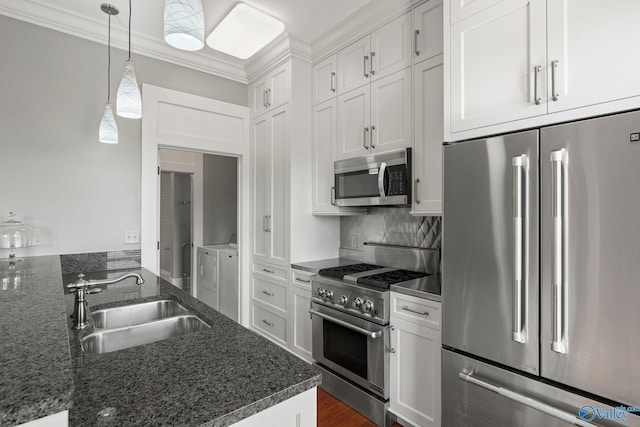 301 NE Holmes Ave Unit 404, Huntsville, AL 35801 - kitchen with high quality appliances, washing machine and clothes dryer, white cabinetry, tasteful backsplash, and ornamental molding