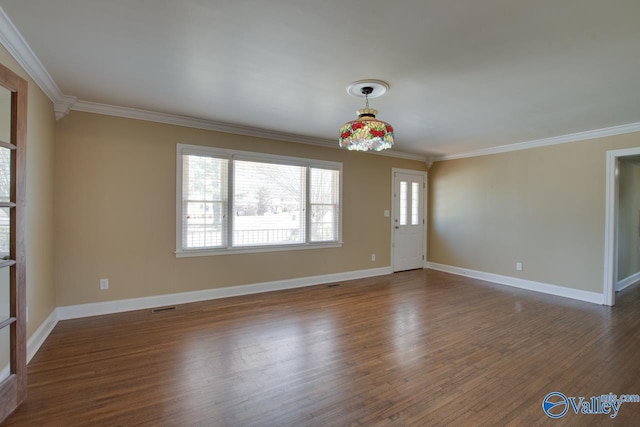 spare room with visible vents, baseboards, ornamental molding, and dark wood-style flooring