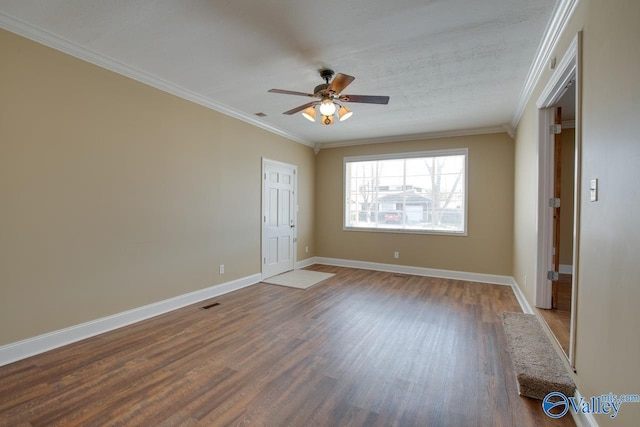 unfurnished room featuring baseboards, wood finished floors, and ornamental molding