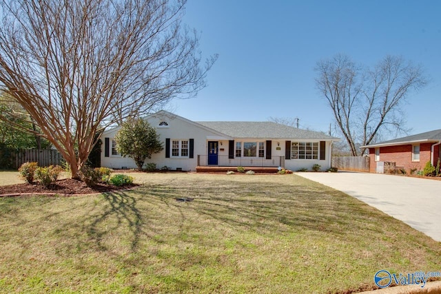 ranch-style home with a front lawn, concrete driveway, fence, and a porch