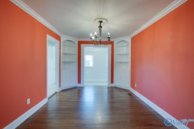 unfurnished dining area with built in shelves, crown molding, baseboards, a chandelier, and dark wood-style floors