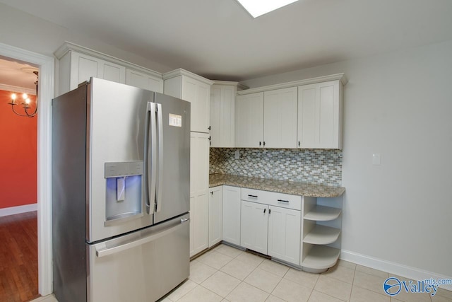 kitchen with backsplash, light tile patterned floors, stainless steel refrigerator with ice dispenser, white cabinets, and open shelves