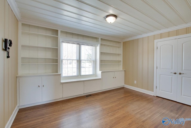 interior space with wood finished floors, visible vents, a closet, and baseboards