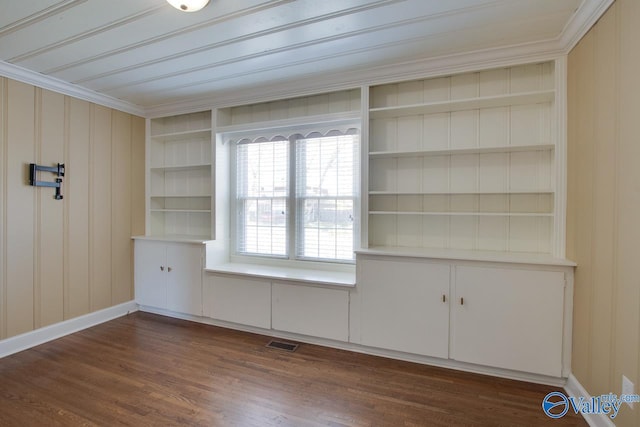 unfurnished room with visible vents, built in shelves, baseboards, and dark wood-style floors