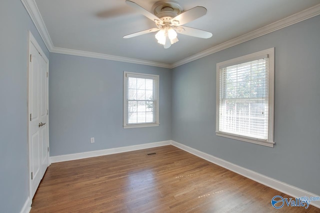 unfurnished room with baseboards, wood finished floors, and ornamental molding