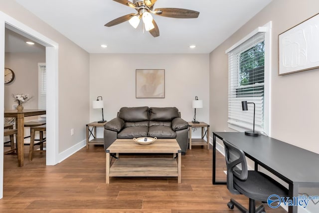 living room featuring wood-type flooring and ceiling fan