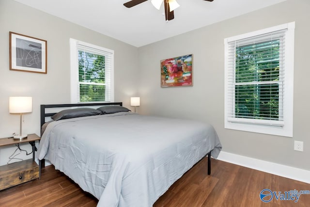 bedroom with dark hardwood / wood-style flooring and ceiling fan