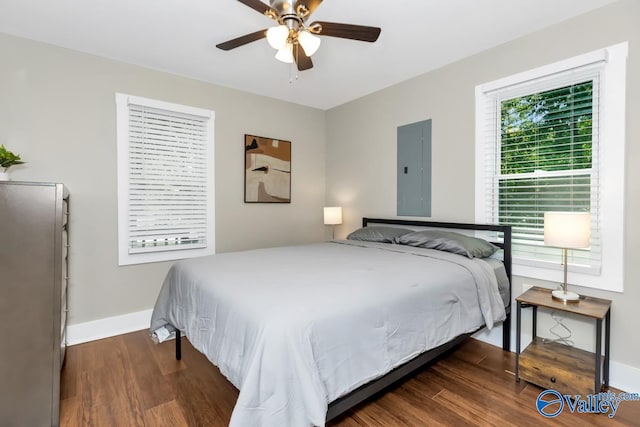 bedroom with electric panel, ceiling fan, and dark hardwood / wood-style flooring