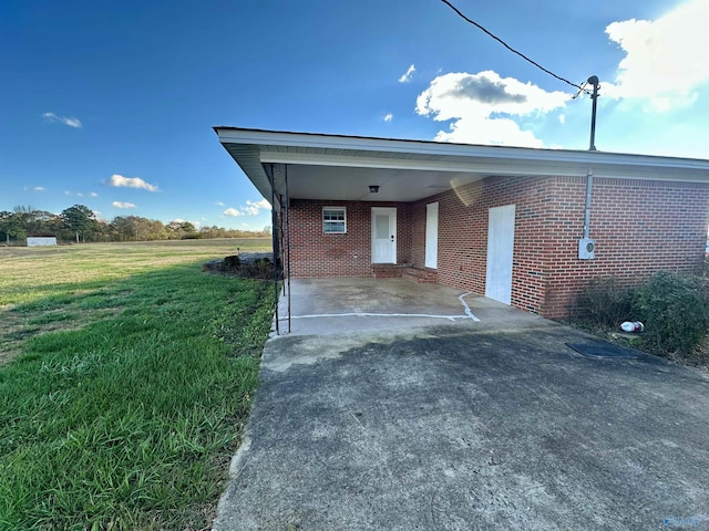 garage featuring a carport and a lawn