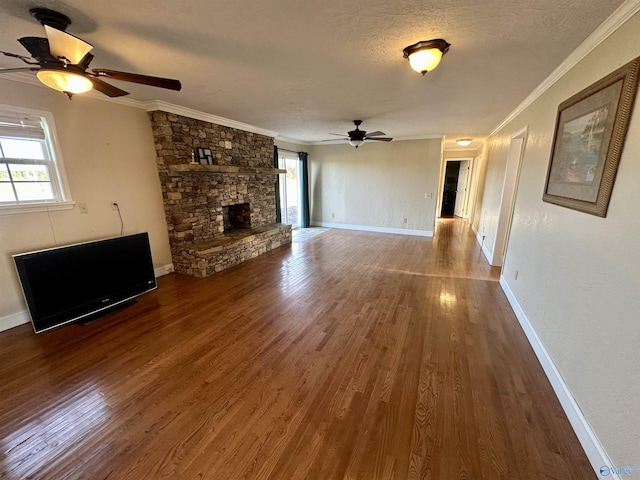 unfurnished living room featuring a fireplace, wood-type flooring, ceiling fan, and crown molding