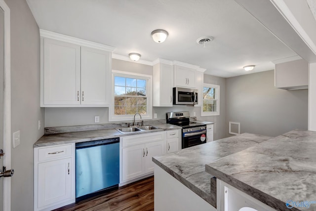 kitchen with stainless steel appliances, white cabinets, visible vents, and a sink