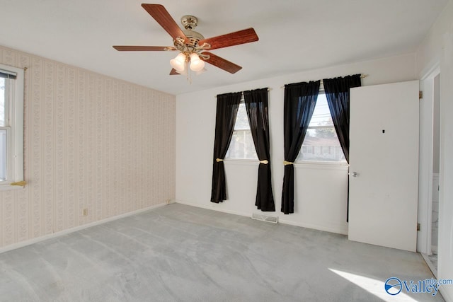 carpeted spare room with ceiling fan