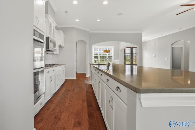 kitchen with white cabinetry, dark hardwood / wood-style floors, a large island, and decorative backsplash