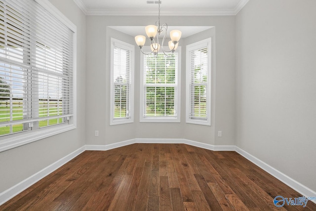 empty room featuring dark wood-type flooring, crown molding, and a chandelier