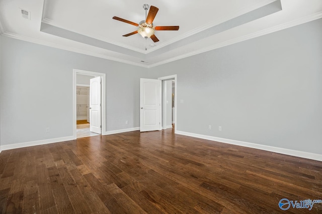 unfurnished room with dark hardwood / wood-style flooring, a tray ceiling, crown molding, and ceiling fan