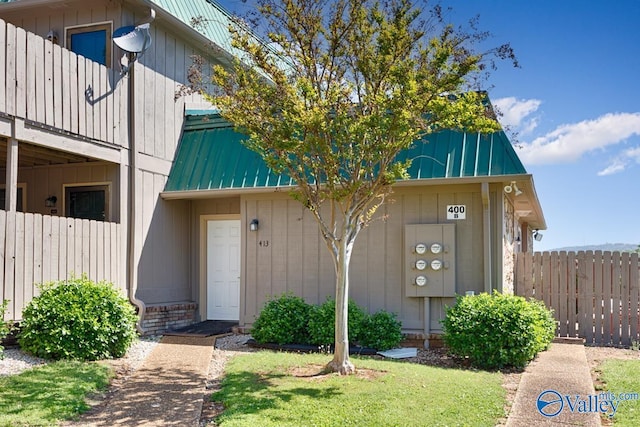 view of exterior entry with metal roof and fence