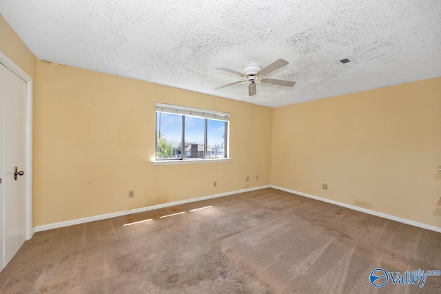 empty room with baseboards, carpet flooring, ceiling fan, and a textured ceiling