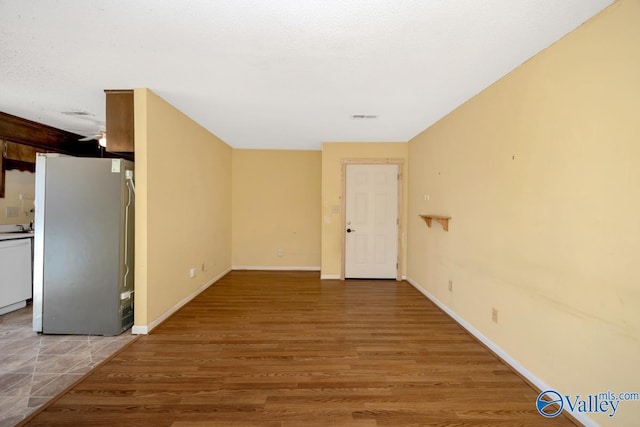interior space featuring baseboards, light wood-type flooring, and visible vents
